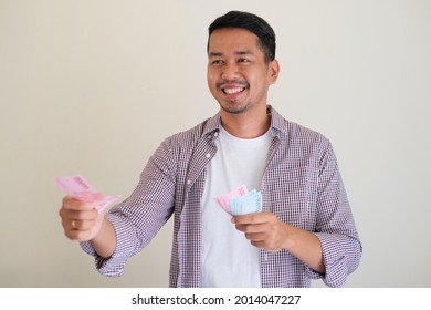 Adult Asian Man Smiling Happy While Giving Money To Someone