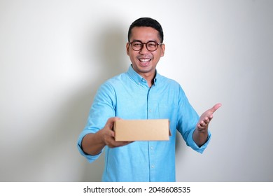 Adult Asian Man Smiling Happy While Giving A Gift Box