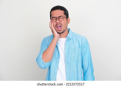 Adult Asian Man Touching His Jaw With Pain Expression