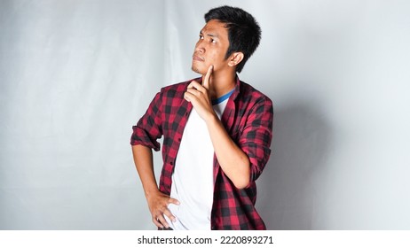 Adult Asian Man Wearing Red Flannel Shirt Showing Thinking Gesture