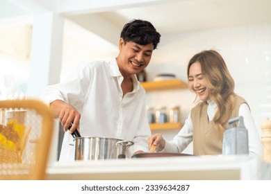 Adult Asian people friends enjoy and fun cooking with talking together in the kitchen at home. Happy man and woman having dinner party meeting celebration eating food together on holiday vacation. - Powered by Shutterstock