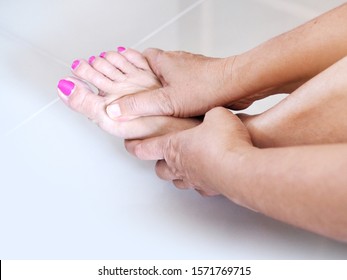 Adult Asian Woman Use Hand Massage On Feet And Toe With Foot Pain And Numb Foot Nerves.