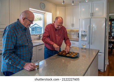 Adult, Baking, Caucasian, Couple, Elderly, Fresh, Fun, Gay, Good Natured, Happy, Home, Husband, Indoors, Jest, Kitchen, Lgbt, Lifestyle, Love, Man, Married, Muffins, People, Playful, Retirement, Senio