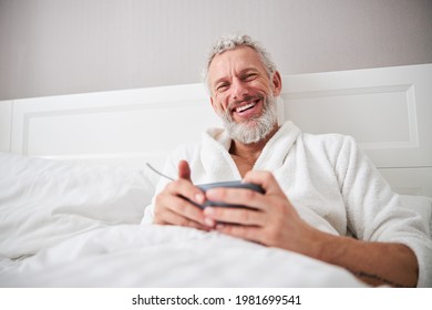 Adult bearded laughing male resting in the morning in home apartment - Powered by Shutterstock