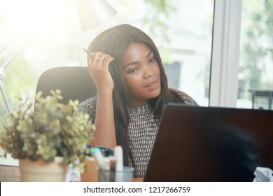 Adult Beautiful Ethnic Woman Scratching Head While Thinking On Problem Watching Computer In Bright Back Lit