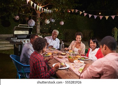 Adult Black Family Enjoying Dinner Together In Their Garden