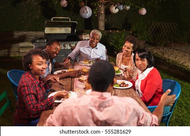 Adult Black Family Talking At Dinner In Their Garden