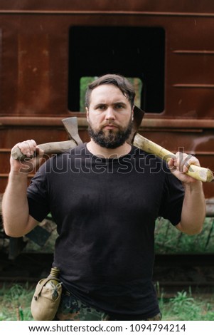 Similar – Image, Stock Photo bearded man huntsman with two axes stands near a rusty train