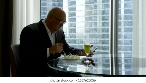 adult businessman is having lunch in restaurant in daytime and reading news tape in social nets - Powered by Shutterstock