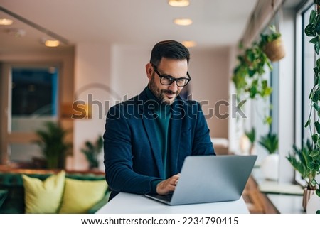 Adult businessman working over the laptop at the workplace.