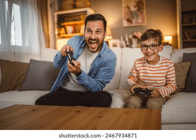 Adult caucasian father and son play video games with joystick at home - Powered by Shutterstock