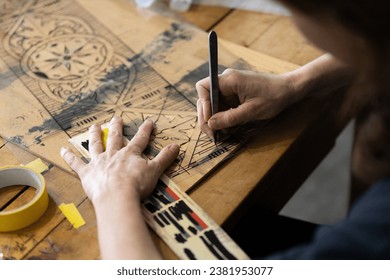 Adult Caucasian Female Expertise Cutting a Wall Stencil Design in her Studio Workshop