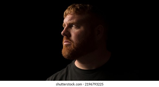 Adult Caucasian male with beard looking sideways in a moody shot. - Shutterstock ID 2196793225