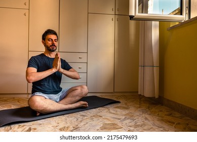 Adult Caucasian Man At Home In The Yoga Position Of The Liberation. Quarantine Training At Home, Fitness, Meditation And Healthy Lifestyle Concept.