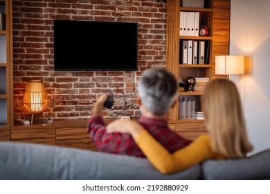 Adult Caucasian Man With Remote Control And Lady Relaxing, Watching Tv With Blank Screen And Enjoy Free Time In Living Room Interior. Couple And Movie Night At Home Together, Entertainment With