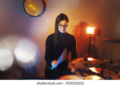 Adult Caucasian Woman Drummer Playing In Dark Room At Home Or Studio - Female Practice Rhythm On Drum Set Music Playing