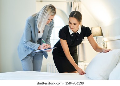 Adult Chambermaid And Hotel Manager Cleaning The Room