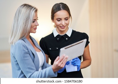 Adult Chambermaid And Hotel Manager Cleaning The Room