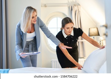 Adult Chambermaid And Hotel Manager Cleaning The Room