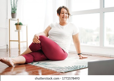 Adult Charming Brunette Woman Plus Size Body Positive Practice Yoga With Laptop At Home