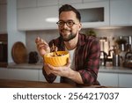 adult cheerful caucasian man enjoy while eat salad at kitchen