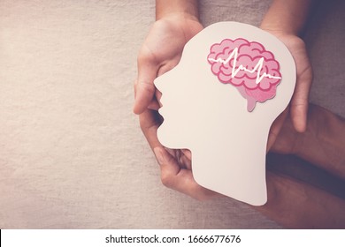 Adult and child hands holding encephalography brain paper cutout,autism, Stroke, Epilepsy and alzheimer awareness, seizure disorder, stroke, ADHD, world mental health day concept - Shutterstock ID 1666677676