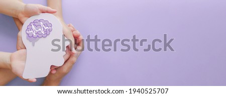 Adult and child hands holding encephalography brain paper cutout,autism, Stroke, Epilepsy and alzheimer awareness, seizure disorder, stroke, ADHD, world mental health day concept Imagine de stoc © 