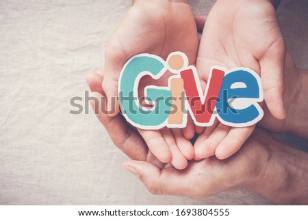 Adult and child hands holding Give word, kind, donate, charity and compassion concept