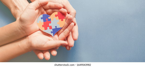 Adult And Child Hands Holding Jigsaw Puzzle Heart Shape, Autism Disorder Awareness, Autism Spectrum Family Support Concept, World Autism Awareness Day