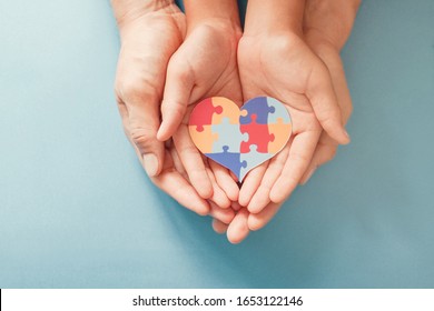 Adult and child hands holding jigsaw puzzle heart shape, Autism awareness, Autism spectrum disorder family support concept, World Autism Awareness Day - Shutterstock ID 1653122146