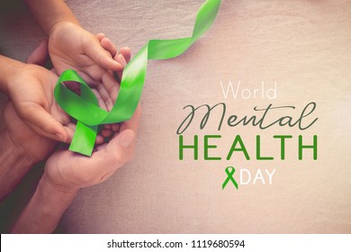 Adult And Child Hands Holding Lime GreenRibbon, World Mental Health Day