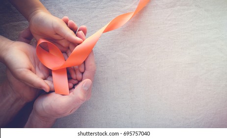 Adult and child hands holding orange Ribbons,  Leukemia cancer awareness and Multiple sclerosis awareness, COPD and ADHD awareness, world kidney day - Shutterstock ID 695757040