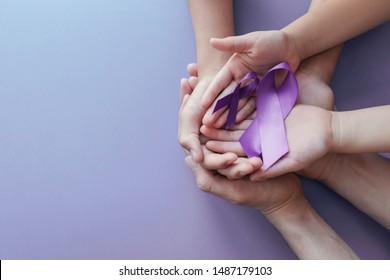 Adult And Child Hands Holding Purple Ribbons, Alzheimer's Disease, Pancreatic Cancer, Epilepsy Awareness, World Cancer Day On Purple Background