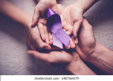 Adult and child hands holding purple ribbons, Alzheimer's disease, Pancreatic cancer, Epilepsy awareness, world cancer day
