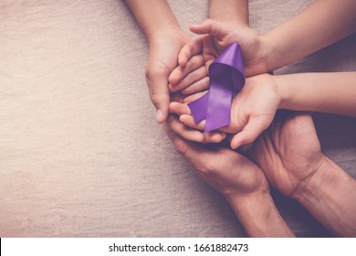 Adult and child hands holding purple ribbon, Alzheimer's disease, Pancreatic cancer, Epilepsy awareness, world cancer day