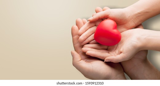 Adult And Child Hands Holding Red Heart On Aqua Background, Heart Health, Donation, CSR Concept, World Heart Day, World Health Day, Family Day