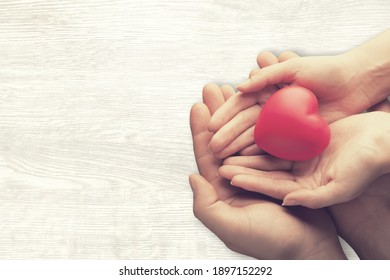 Adult And Child Hands Holding The Red Heart