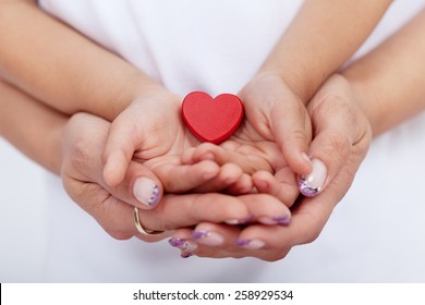 Adult and child hands holding red heart together-shallow depth of field - Shutterstock ID 258929534