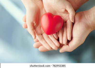 Adult And Child Hands Holding Red Heart