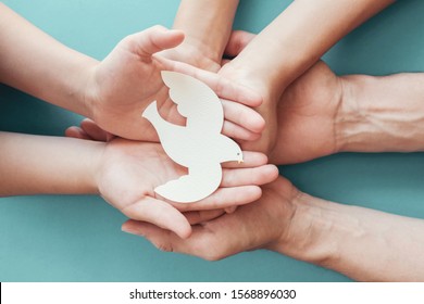 Adult and child hands holding white dove bird on blue background, international day of peace or world peace day concept, sustainable consumption, csr responsible business, animal rights, hope concept - Shutterstock ID 1568896030