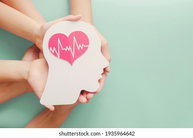 Adult and children hands holding paper brain and heart, brain stroke, world heart day, world mental health day, Alzheimer and wellness concept