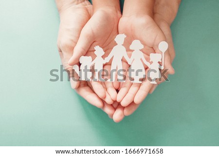 Adult and children hands holding paper family cutout, life insurance planning, adoption, foster care, homeless support, family mental health, family wellness, social distancing concept