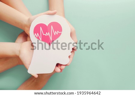Adult and children hands holding paper brain and heart, brain stroke, world heart day, world mental health day, Alzheimer and wellness concept