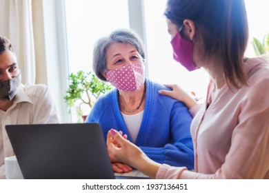 Adult children have fun and chat with an elderly mother and watch content and information on the Internet - Relatives communicate together in the context of the coronavirus pandemic