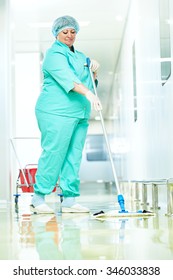 Adult cleaner woman in uniform with mop cleaning corridor pass floor of pharmacy industry factory or medical clinic