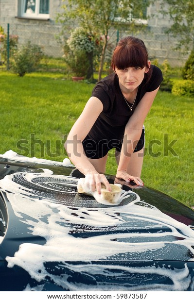 Adult cleaning her car\
outside