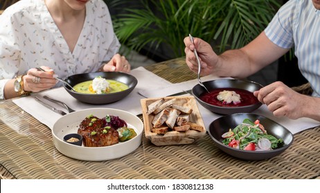 An Adult Couple Having Lunch On A Summer Terrace Of A Posh Restaurant, Set Table With Fine Dining Meals, No Faces