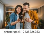 Adult couple man and woman husband wife have a cup of coffee use mobile phone search internet social network happy smile