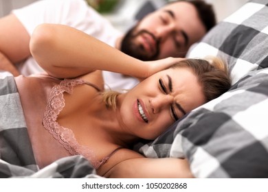Adult Couple Suffering From Snoring Problem In Bed