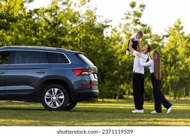 Adult couple with their little children having picnic in the Park Outside the City, Family Weekend Concept, People Enjoying Summer - Powered by Shutterstock